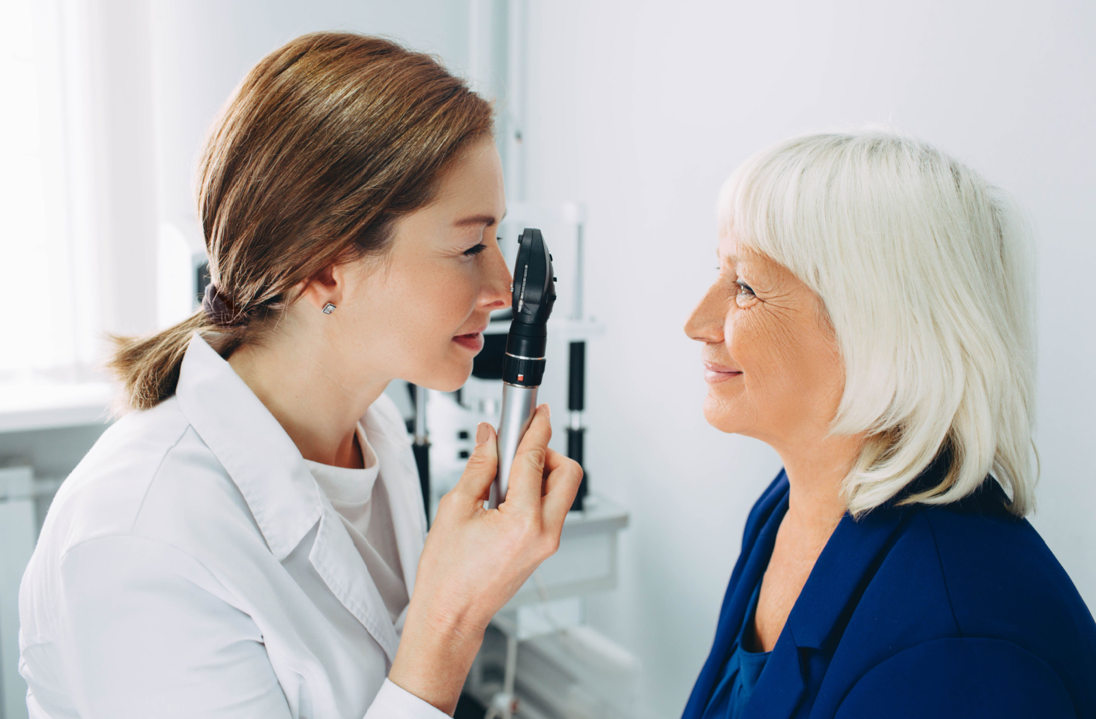 A female optometrist examines a female patient's eyes