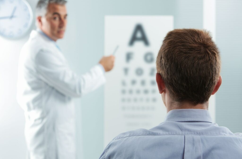 View from behind a patient's head as he sits in a chair and looks at a Snellen chart as directed by the optometrist.