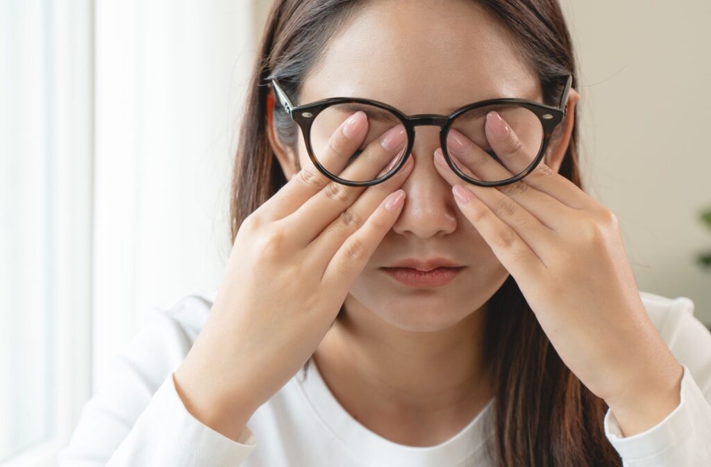 A woman pressing her eyes in discomfort.