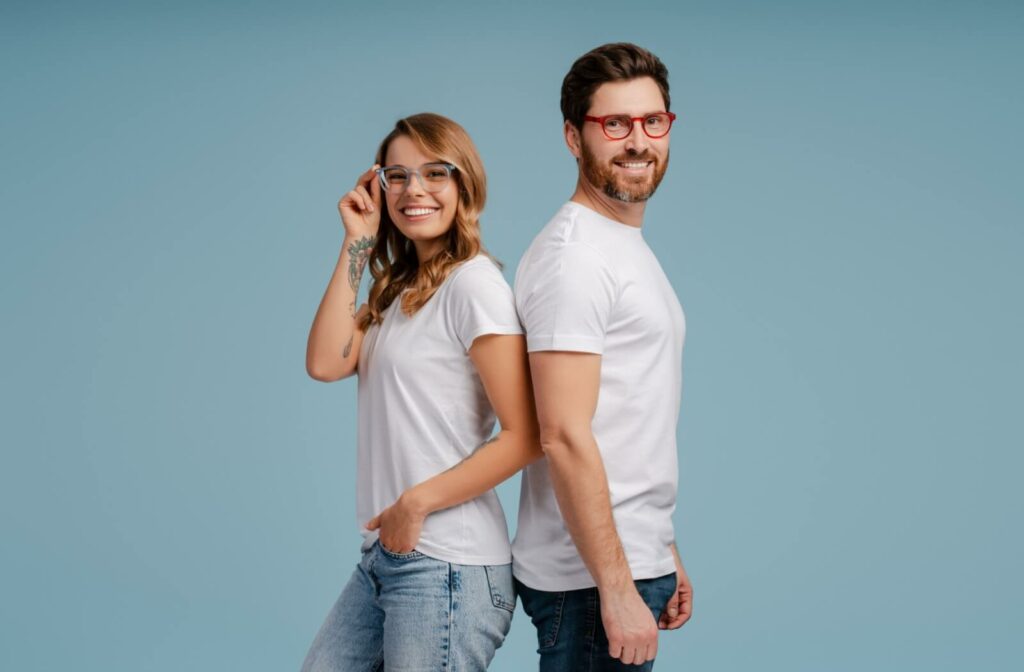 Two people stand back to back, smiling while wearing their single vision glasses.