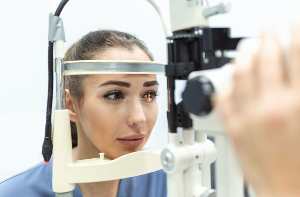 Woman undergoing a slit lamp eye exam at an optometry clinic, with focused lighting on her pupil to check for signs of diabetic eye conditions.